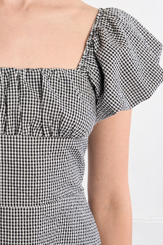 Black and white checkered dress with puff sleeves on a white background