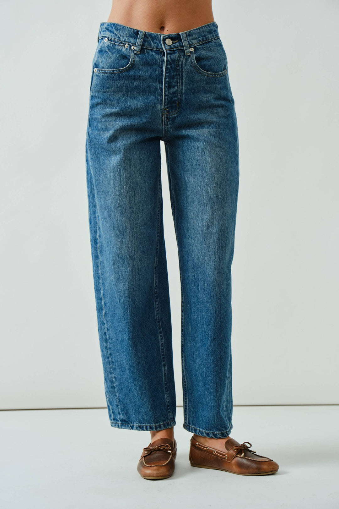 Blue jeans worn by a person on a white background