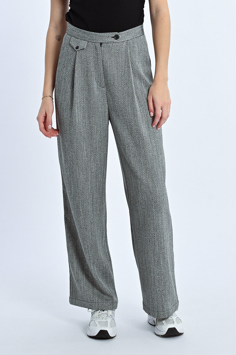 Person wearing gray checkered pants on a white background