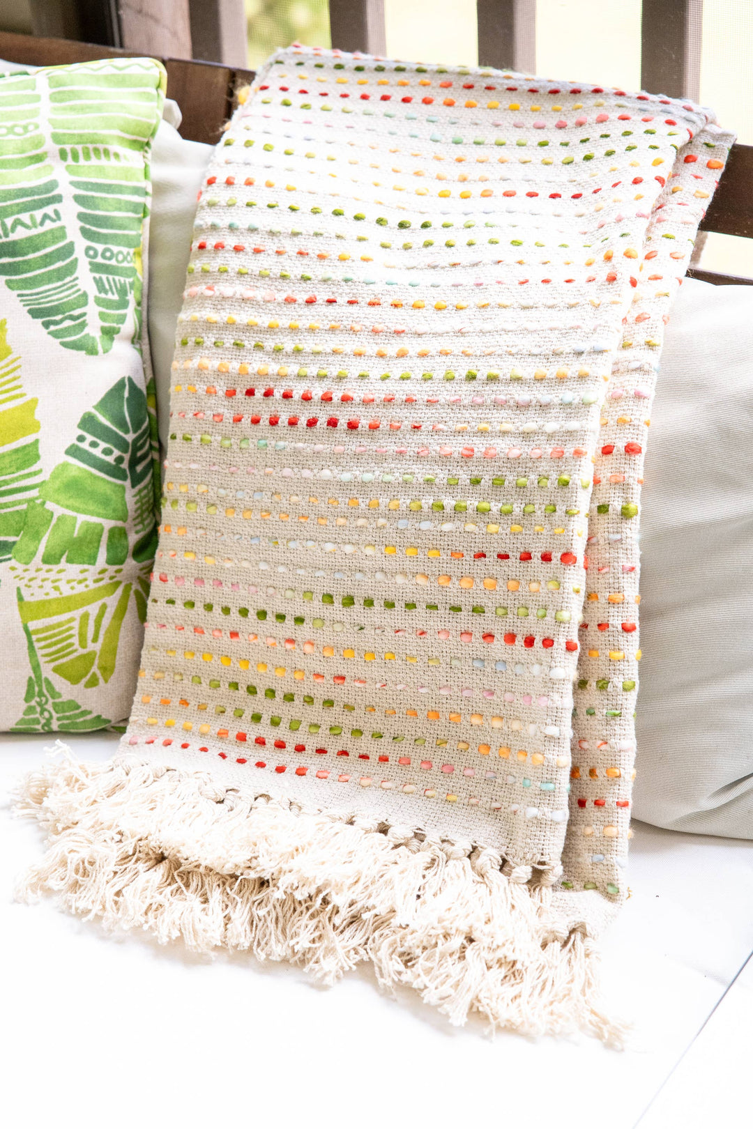 Textured blanket with colorful pattern draped over a chair