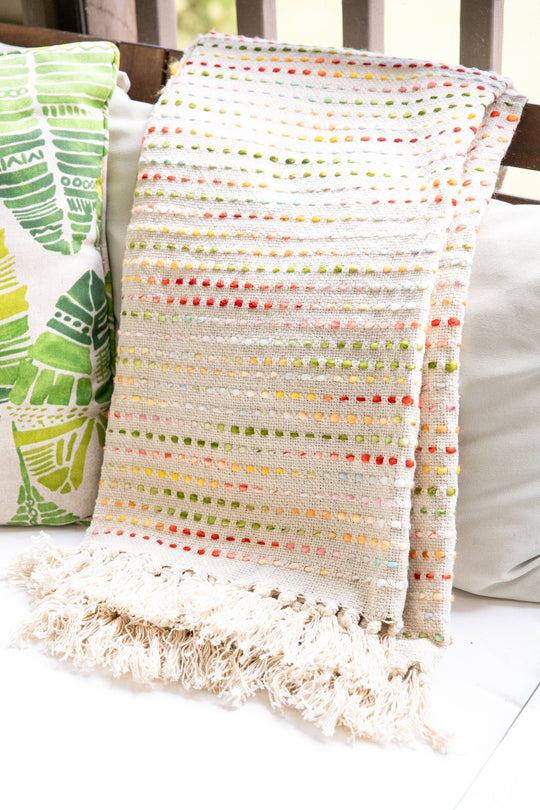 Textured blanket with colorful pattern draped over a chair