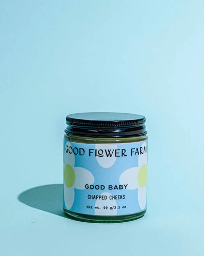 Jar of 'Good Baby' chapped cheeks cream from Good Flower Farm on a light blue background