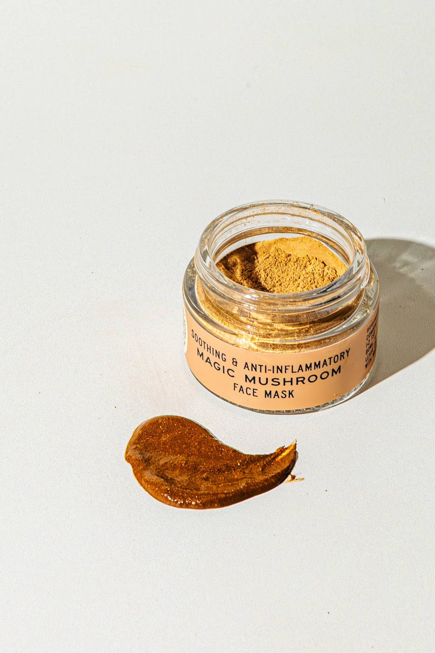 Jar of magic mushroom face mask with a swatch on a white background