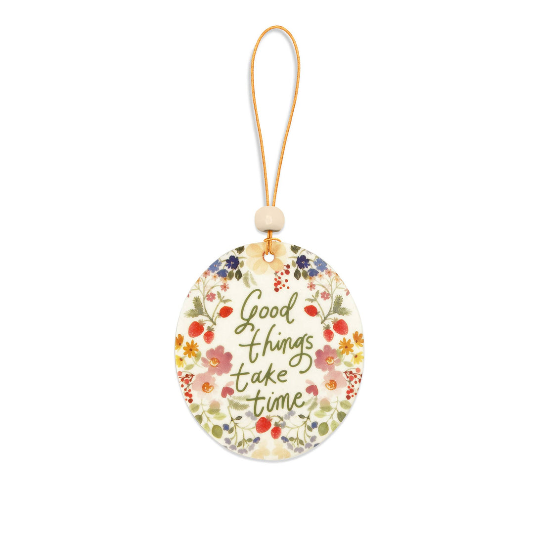 Decorative tag with floral design and 'Good things take time' text on a white background