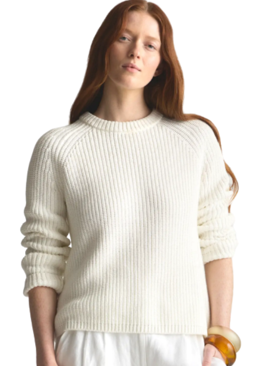 Woman wearing a white sweater on a plain background