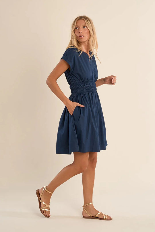 woman wearing a navy dress with cinched waist