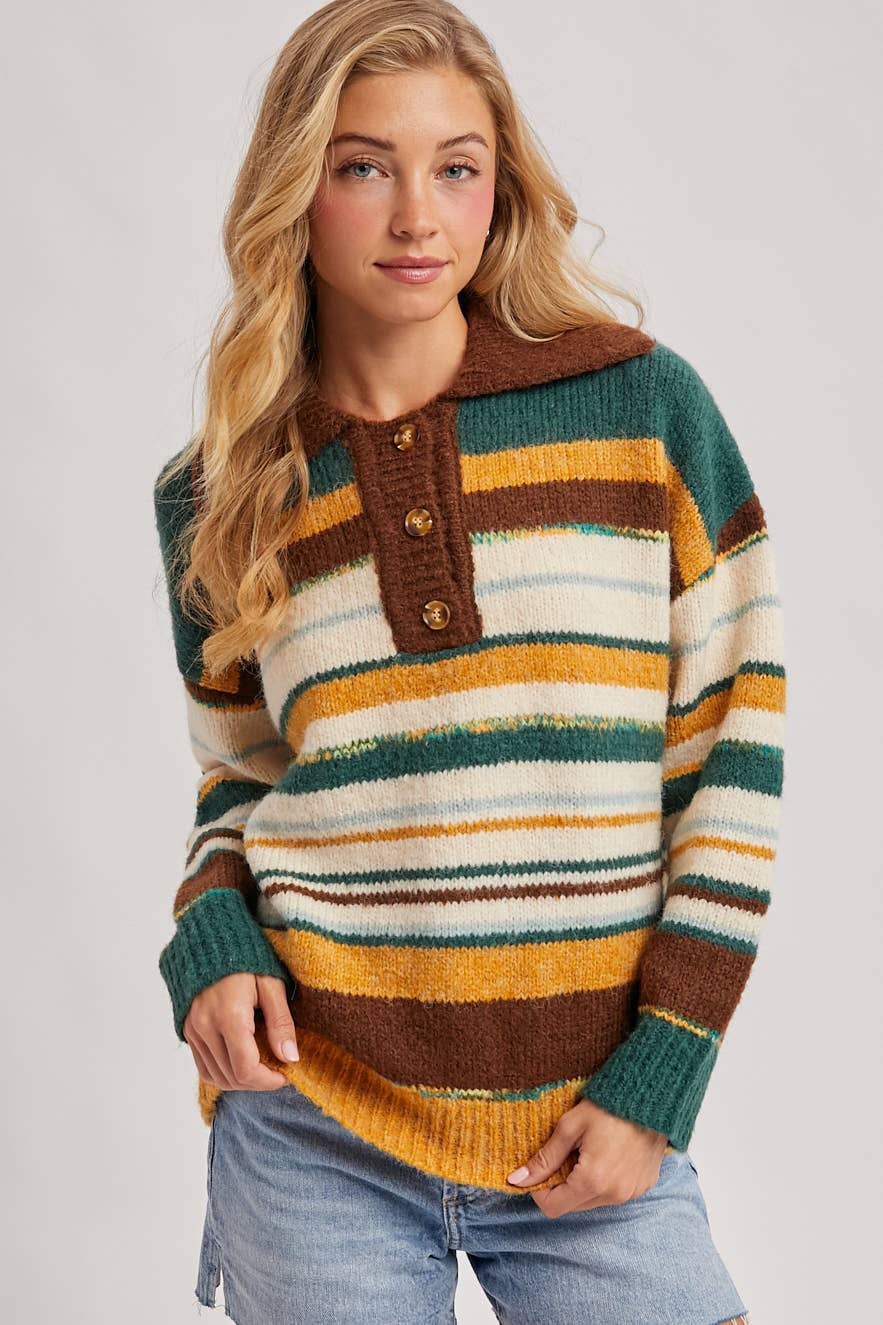 Woman wearing a colorful striped sweater with a plain background