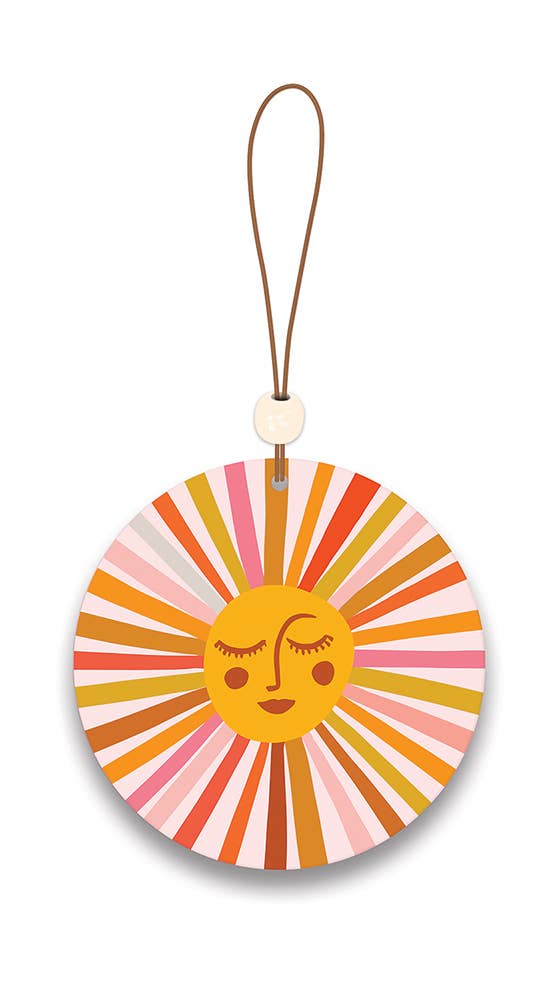 Colorful circular car freshener with a sun design on a white background