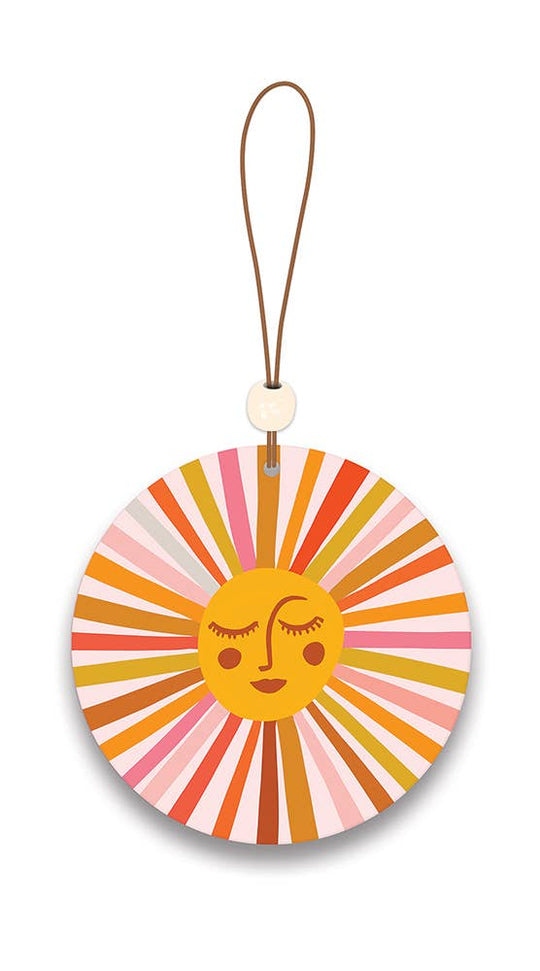 Colorful circular car freshener with a sun design on a white background