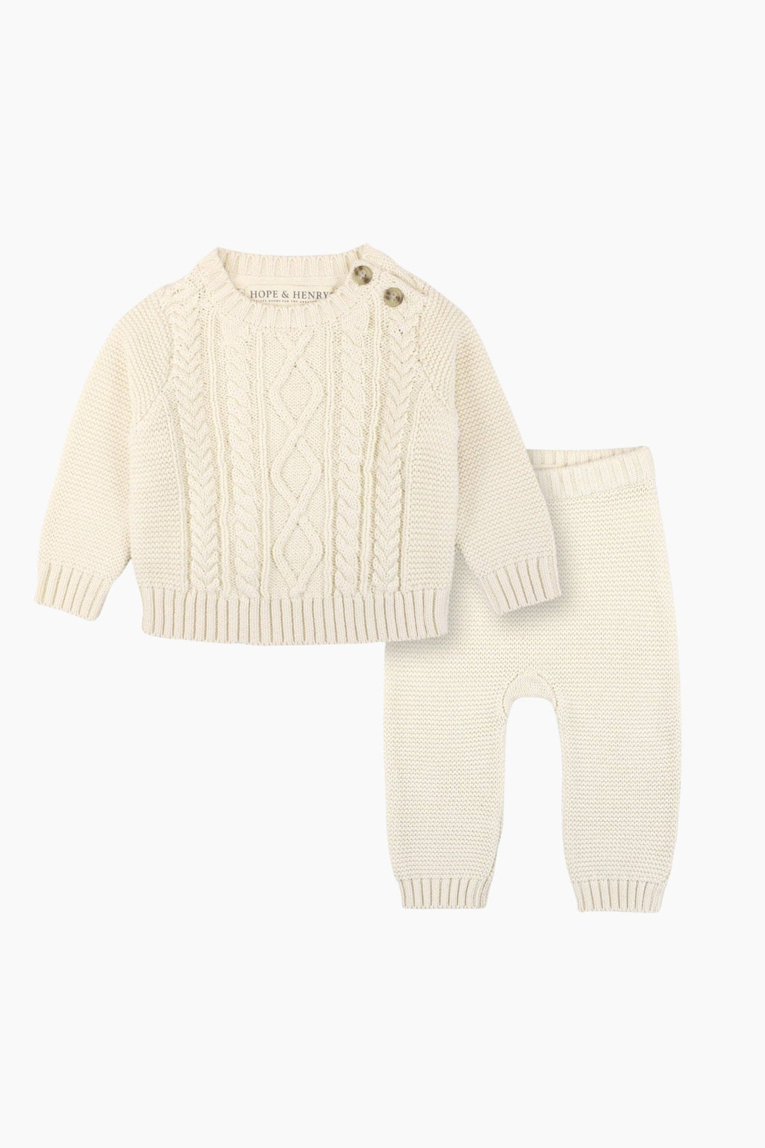 Knitted baby sweater and pants set on a white background