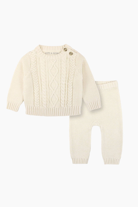 Knitted baby sweater and pants set on a white background
