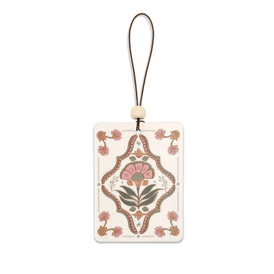 Decorative car freshener with floral design on a white background
