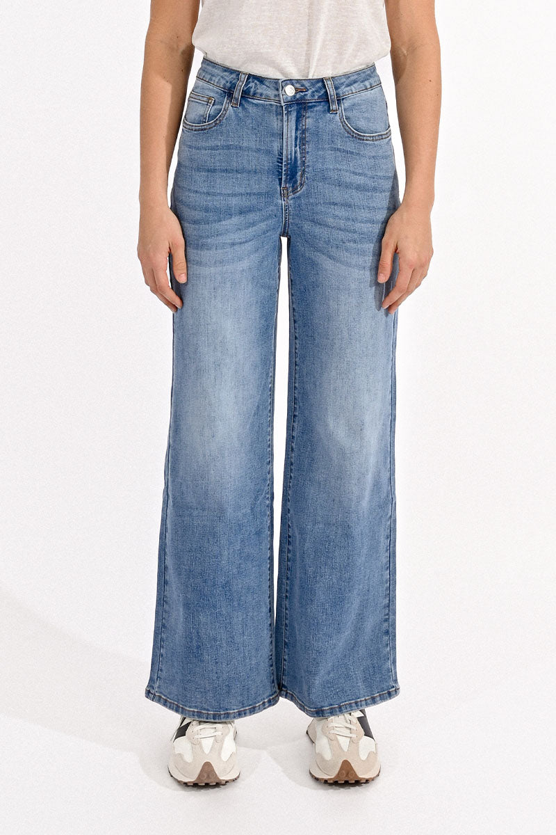 Person wearing blue wide-leg jeans on a white background